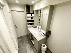 A modern bathroom with a white sink, mirror, and storage cabinets. - Residenza La Giacca (Tokyo)