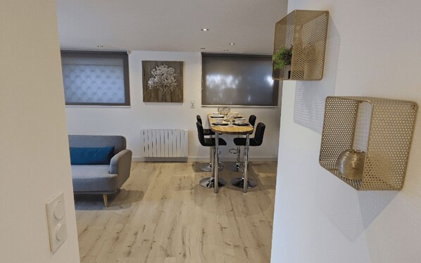 Un espacio habitable compacto con comedor, sofá y radiador.
