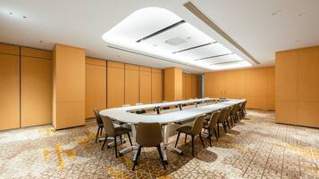 A conference room with a long table, chairs, and a patterned floor.