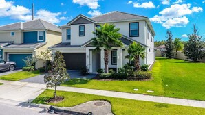 A modern two-story house with a garage, a driveway, and a well-maintained lawn. - Relax in Style: Elegant Vacation Home in Orlando (Kissimmee)