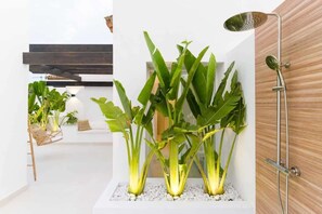 A modern bathroom with a shower, a white sink, and a plant arrangement. - Altos La Quinta | Sea View Luxury Penthouse (Benahavís)