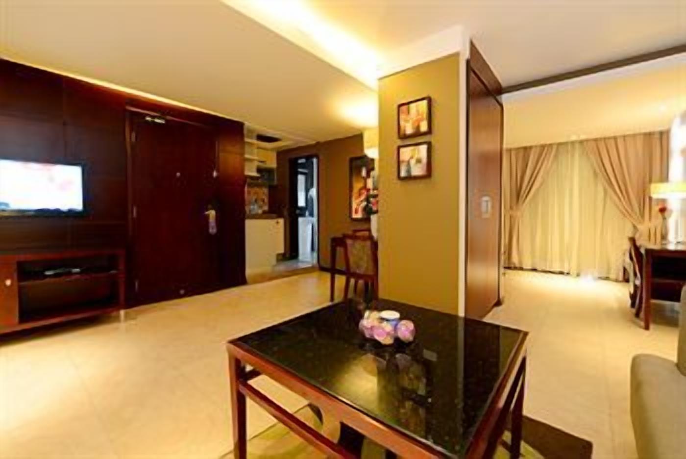 Une chambre d’hôtel équipée d’une table à manger, d’un téléviseur et d’un coin cuisine.