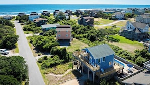 Uma área residencial costeira com casas, uma estrada e uma praia.