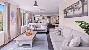 A modern living room with a sofa, coffee table, and artwork on the wall.