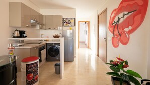 A modern kitchen with a washing machine, a refrigerator, and a large mural of lips on the wall. - Maryline's waterfall with Piscine & Rooftop (Casablanca)
