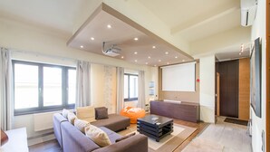 A modern living room with a sofa set, a coffee table, and a projector screen. - Venus Apartments - Parliament I (Budapest)
