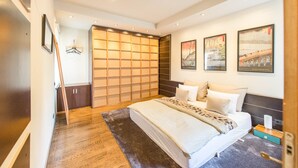 A modern bedroom with a large bed, a wardrobe, and a sliding door closet. - Venus Apartments - Parliament I (Budapest)