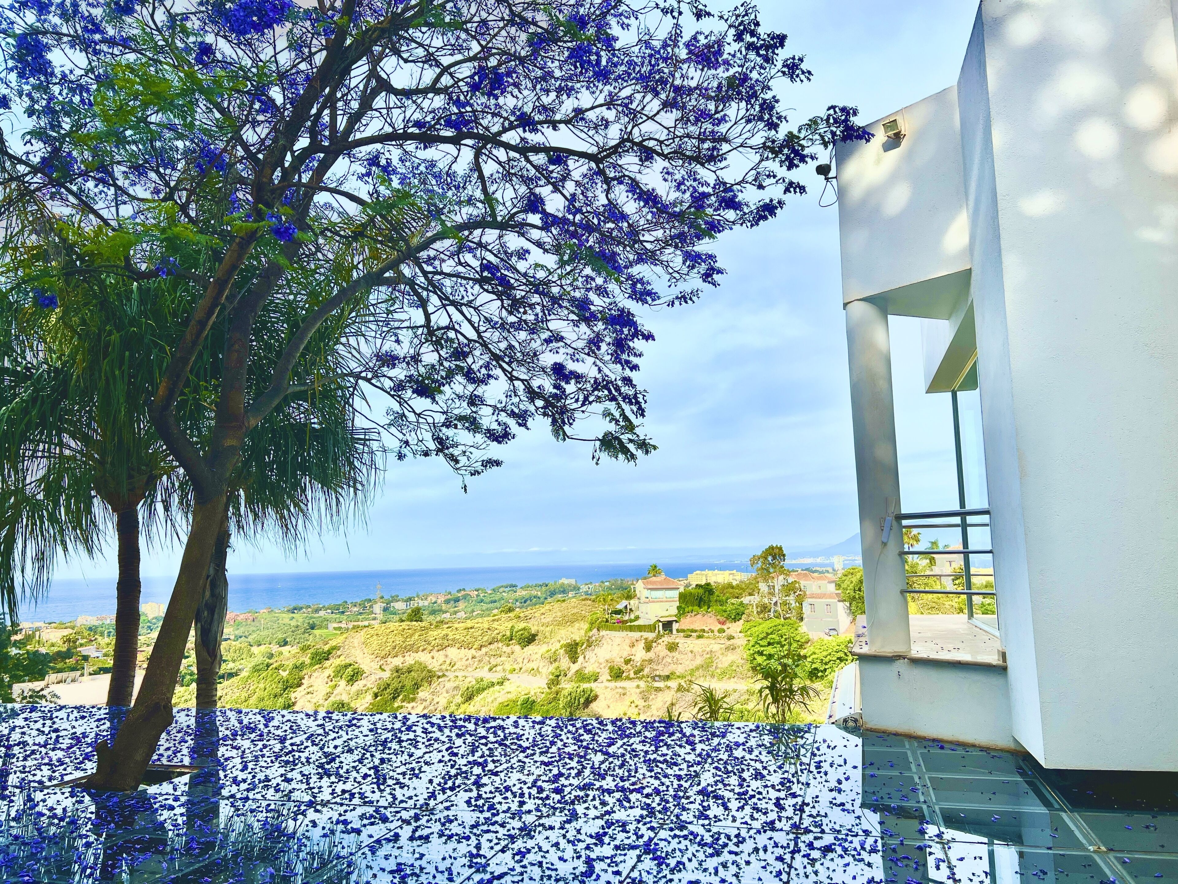 A modern building with a glass terrace and a view of the sea.