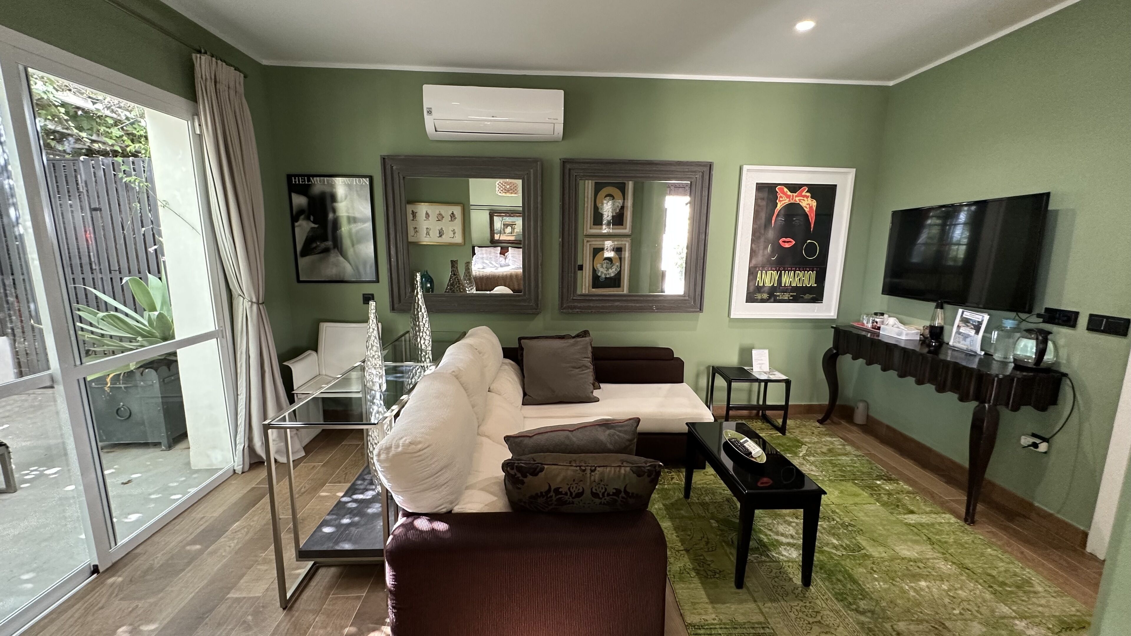 Ein Wohnzimmer mit einer Couch, einem Couchtisch, einem Fernseher und gerahmten Bildern an der Wand.