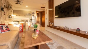 A modern living room with a wooden coffee table, a sofa, and a TV mounted on the wall. - Vintage Dead Sea with Pool & Rooftop (Casablanca)