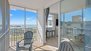 Ein Balkon mit zwei Stühlen, einem Tisch und Blick auf die Stadt.