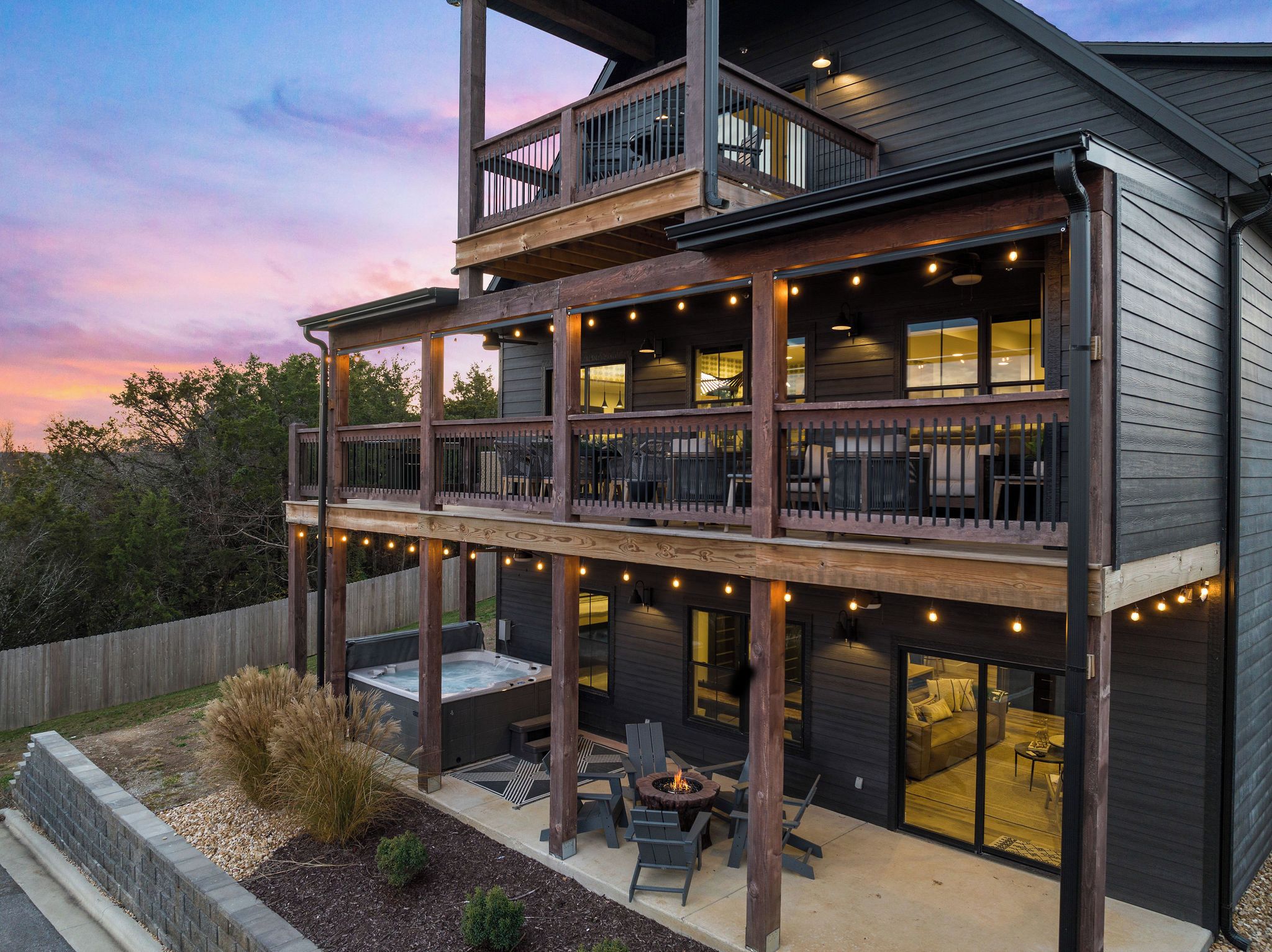 A two-story building with a balcony, outdoor seating area, and a fire pit.