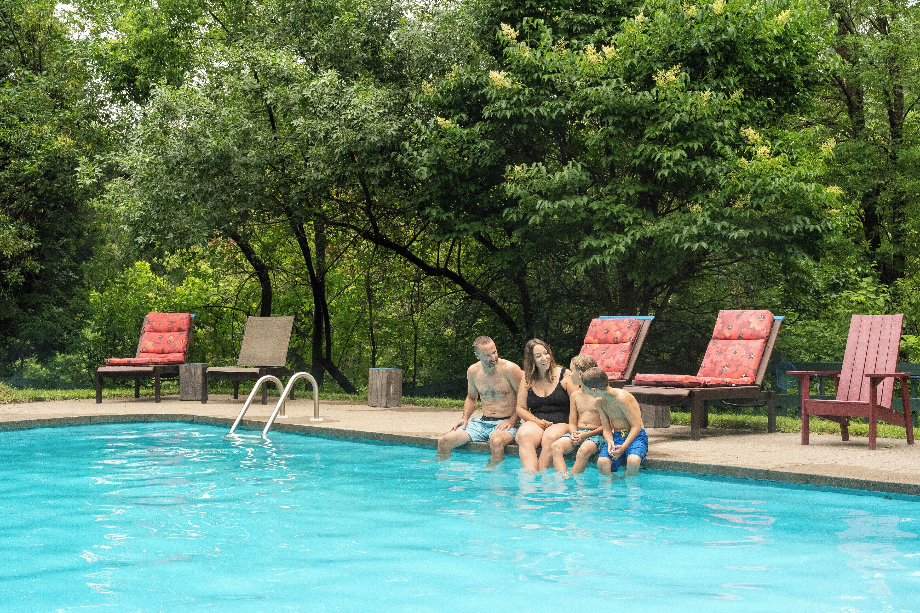 Une piscine avec des chaises rouges et une terrasse en bois.