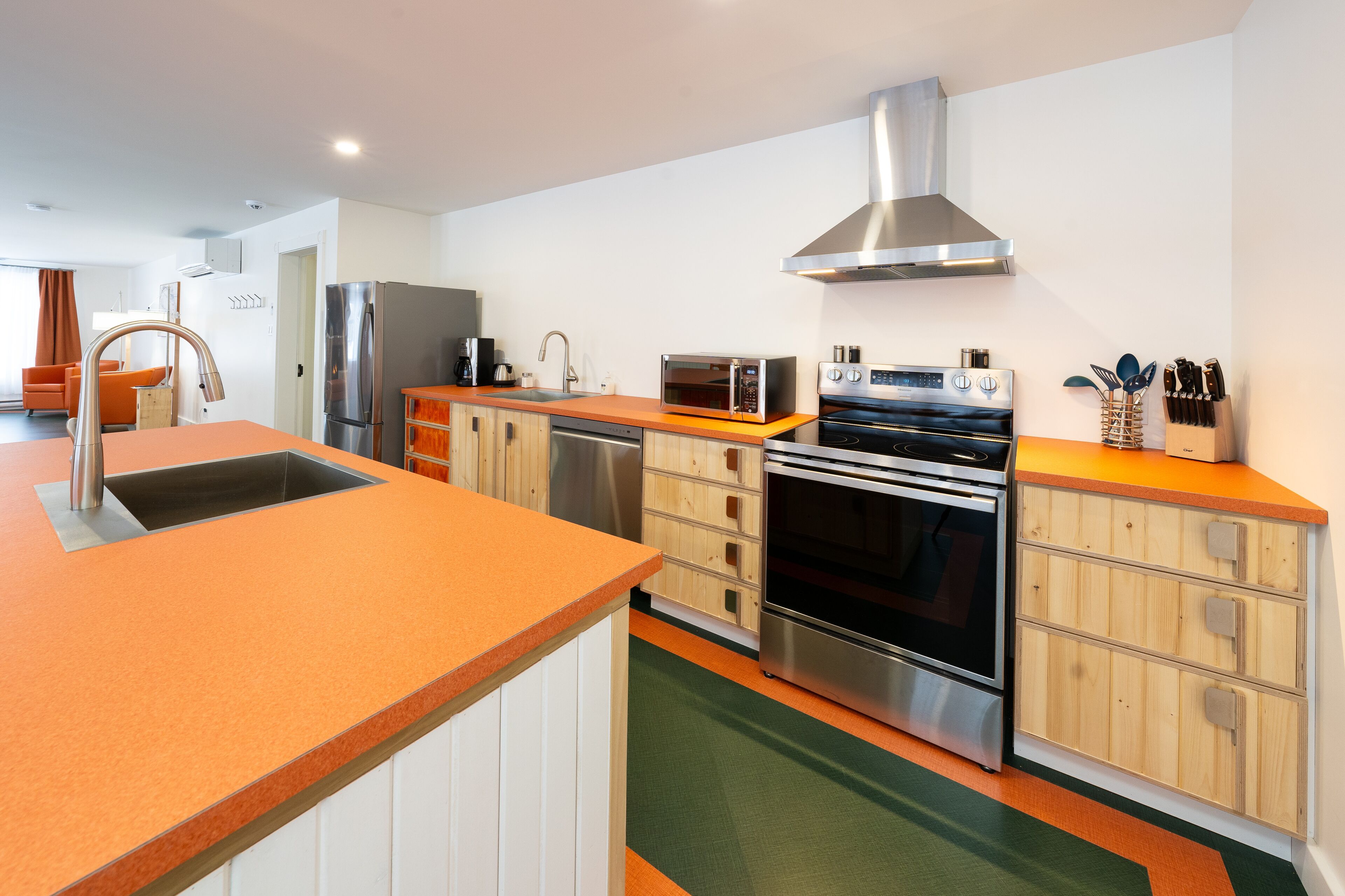 A modern kitchen with a stainless steel refrigerator, microwave, oven, and a sink.