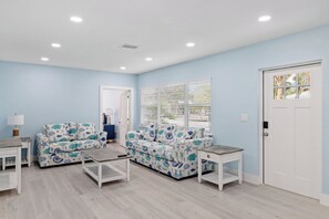 Une pièce avec un mur bleu clair, des meubles blancs et une porte dotée d’une fenêtre.