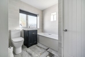 A bathroom with a toilet, a sink, and a bathtub. - Torquay 3-bed House, Sleeps 6, Pets Ok & Parking (Torquay)