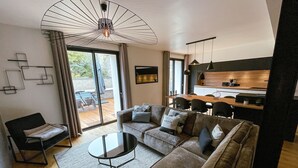 A modern living room with a sofa, a coffee table, and a dining area with chairs.