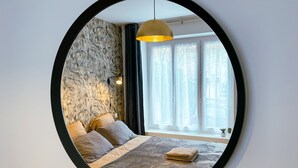 A bedroom with a bed, a lamp, and a window with curtains.
