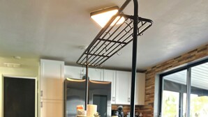 Een moderne keuken met een houten tafel, een hanglamp en uitzicht op de omgeving door grote ramen.