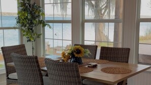 Ein Essbereich mit Korbstühlen und einem Tisch, gedeckt mit Untersetzern und einer Sonnenblumen-Dekoration.