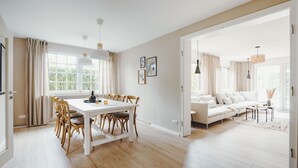 Un grand espace de vie comprenant une table à manger, des chaises, un canapé et une table basse.