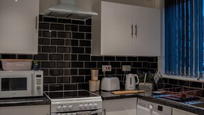Eine moderne Küche mit Mikrowelle, Herd, Backofen und Waschmaschine.