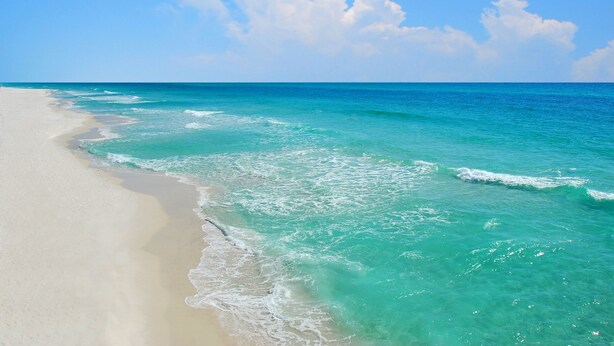 Una playa con agua turquesa cristalina y arena blanca.