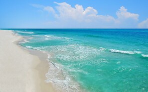 A beach with clear turquoise water and white sand.