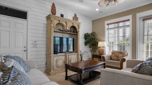 Una sala de estar con chimenea, televisor, mesa de centro y sofá.