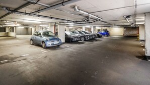 A multi-level underground parking garage with several cars parked. - 2-bed Apartment Near Basildon Train Station (Basildon)