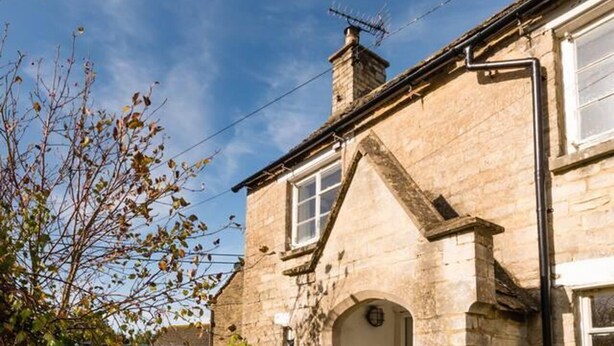 A stone house with a white door, a chimney, and a small garden area. - Lovely Cosy Stone Cottage in Tetbury, Cotswolds (Tetbury)