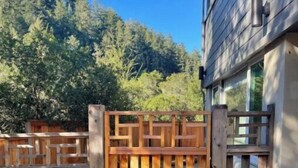 A wooden gate leading to a house with a view of a forested hillside. - Luxe modern Lagunitas studio at Samuel P Taylor (Lagunitas-Forest Knolls)