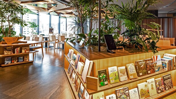 A modern library cafe with wooden furniture, bookshelves, and large windows allowing natural light. - Comfort Hotel Yokkaichi (Yokkaichi)