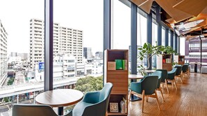 A modern interior with large windows, wooden flooring, and a view of a cityscape. - Comfort Hotel Yokkaichi (Yokkaichi)