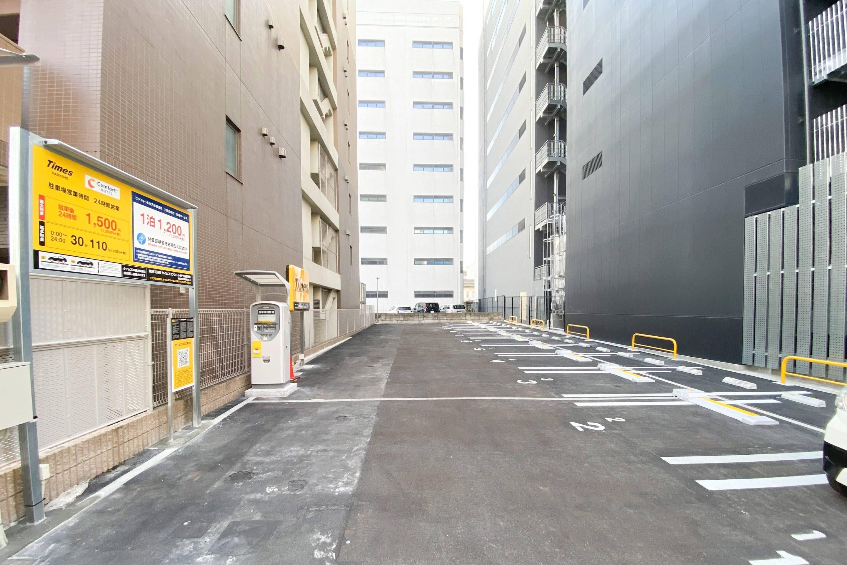 A parking lot with marked spaces, a vending machine, and a Times advertisement on a building.