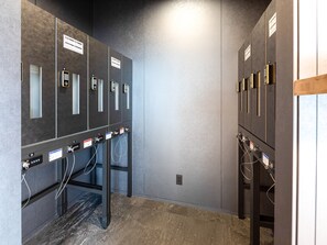Área moderna de elevadores, com vários elevadores, painéis de comando e design industrial limpo.