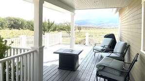 Eine überdachte Veranda mit Blick auf einen Weinberg und Berge.