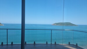 Un balcon offrant une vue dégagée sur la mer et une petite île.