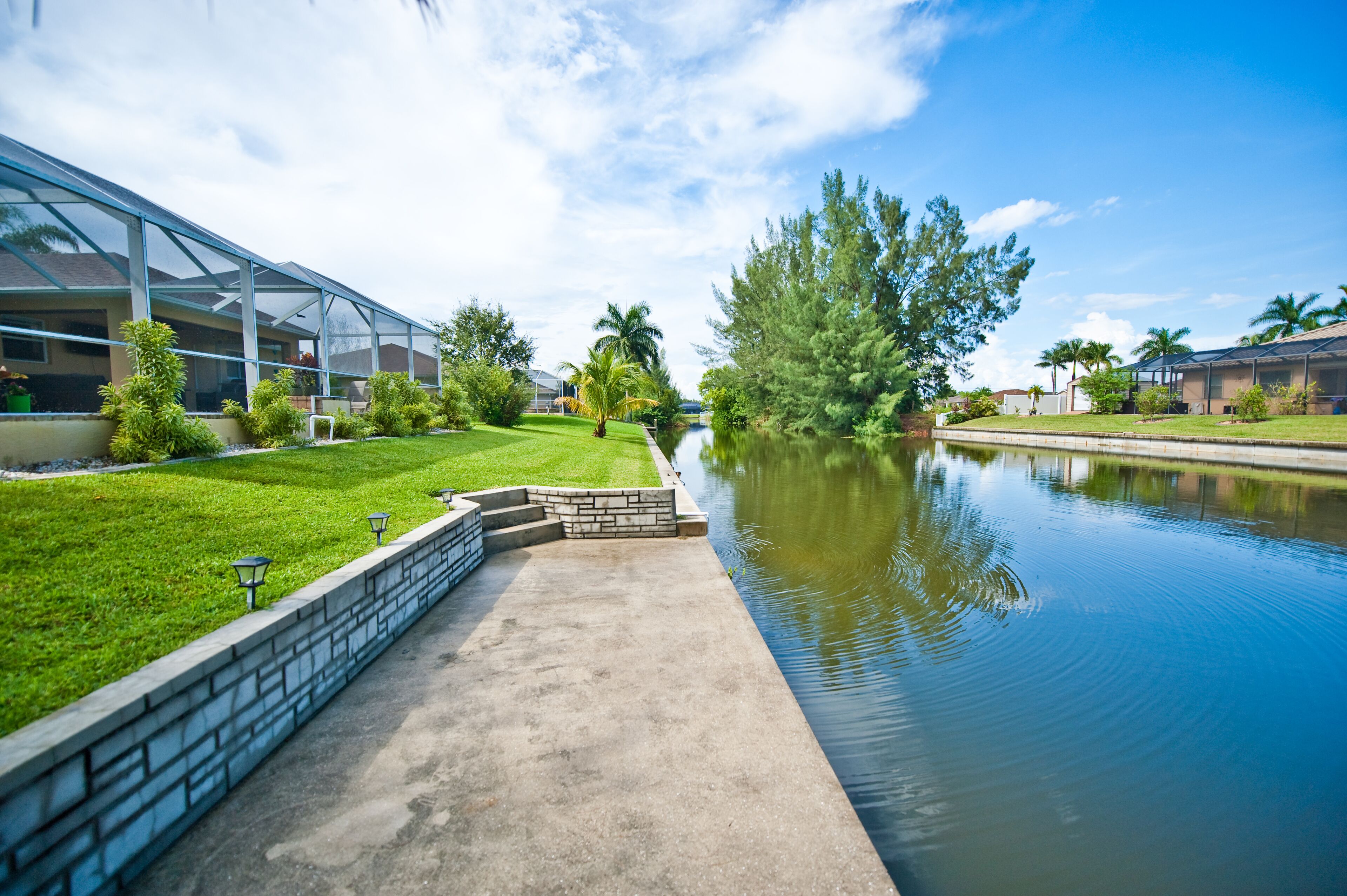 Une cour paisible agrémentée d’un élément aquatique, un bâtiment entièrement vitré et des jardins bien entretenus.