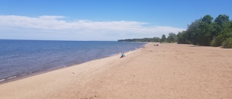 Na praia, espreguiçadeiras, toalhas de praia 