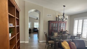 A spacious living room with a leather sofa, a dining area with a glass table, and a wooden bookshelf. - Desert Ridge * Location Location Location  (Phoenix)
