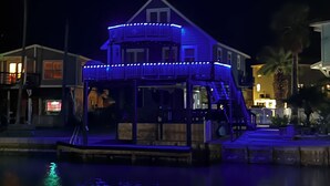 Un edificio sul lungomare con un balcone e un molo che si protende nell'acqua.