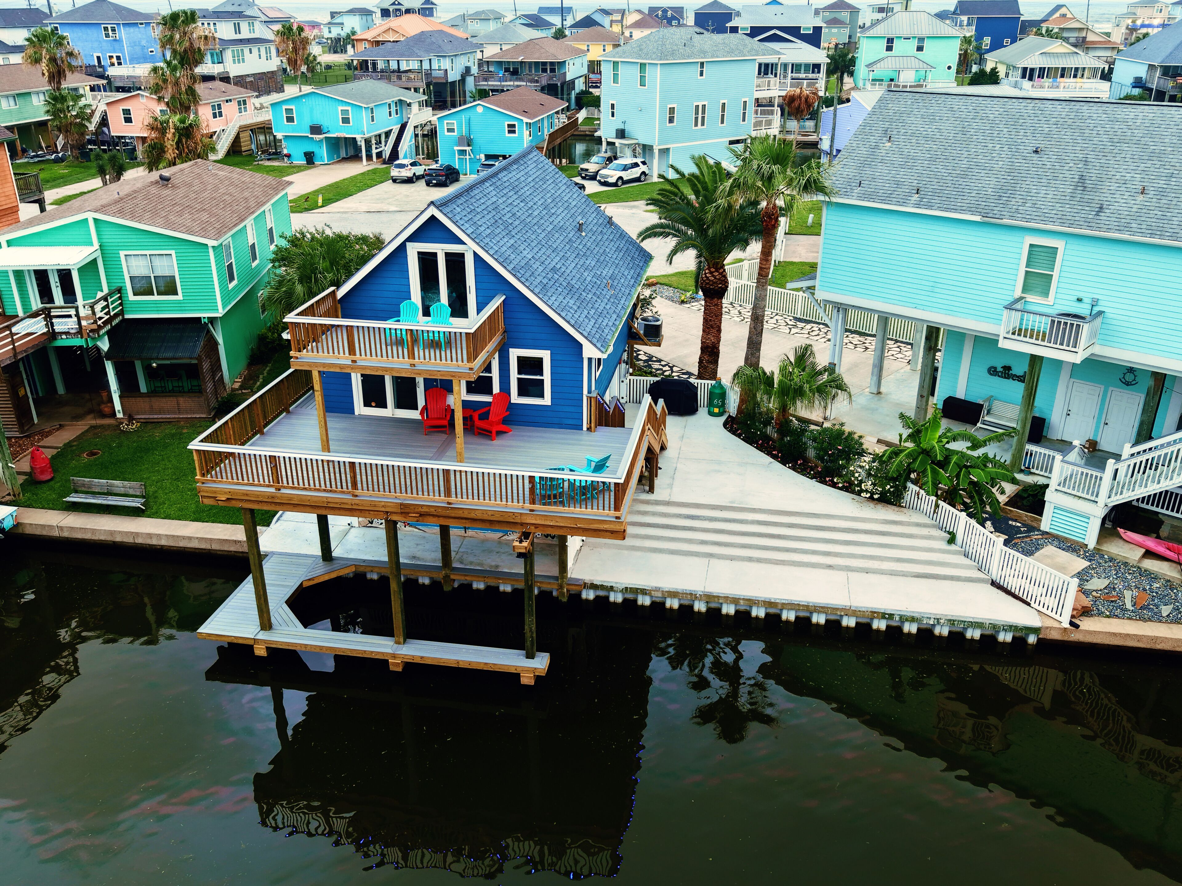 A house with a balcony and a dock extending into a body of water.