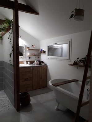 Bathroom features a bathtub, large mirror, and natural light.