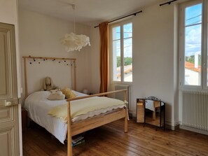 Cozy bedroom with a four-poster bed, plush pillows, and a large window offering a view of the outside.
