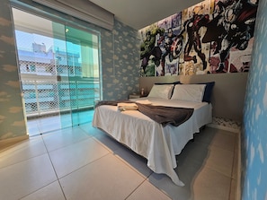 Un dormitorio con una cama, un ventanal grande y un mural en la pared.