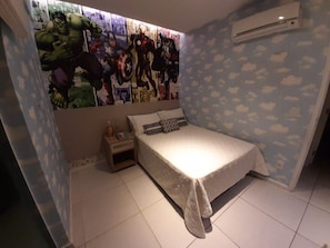 A bedroom with a bed, a nightstand, a wall mural, and an air conditioning unit.