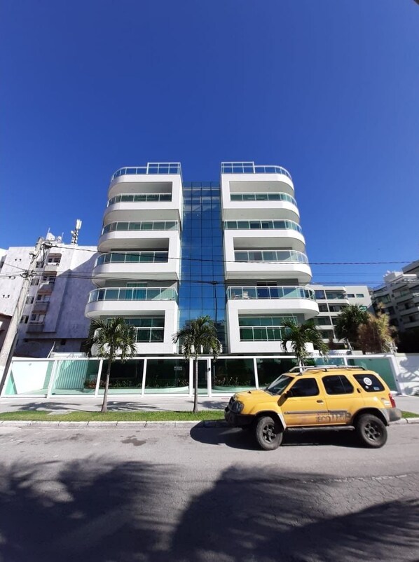A multi-story building with a modern design, featuring balconies and large windows.