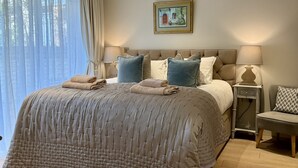 A bedroom with a large bed, a bedside table, a lamp, and a chair. - Walcot Yard in Bath (Bath)