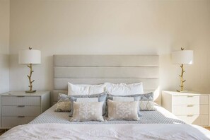 A neatly arranged bedroom with a large bed, two bedside tables, and a headboard. - Opulent 4 Bedroom Townhouse (Big Sky)
